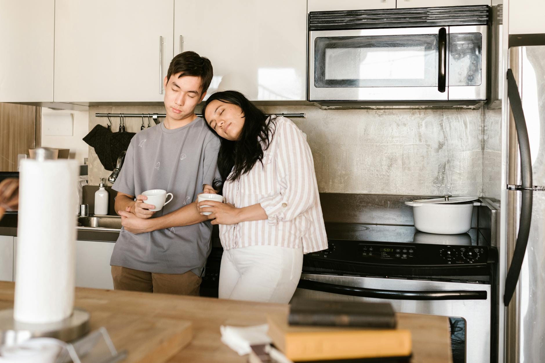 Brak energii po przebudzeniu: czy winne jest śniadanie, kolacja czy odwodnienie? Para pije poranną kawę w kuchni, spokojny start dnia