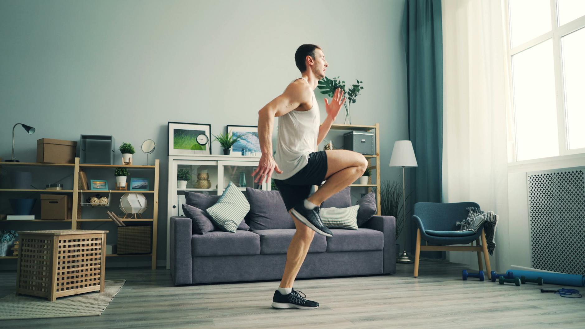Mężczyzna w sportowym stroju robi cardio w salonie