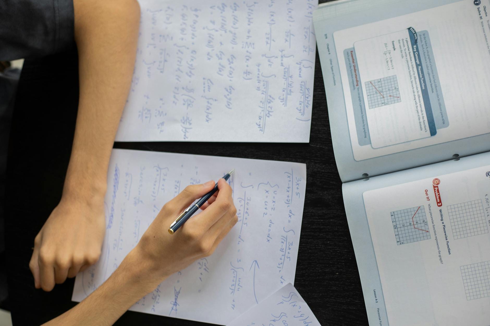 Uczeń zapisuje rozwiązania zadań z matematyki na kartce podczas lekcji
