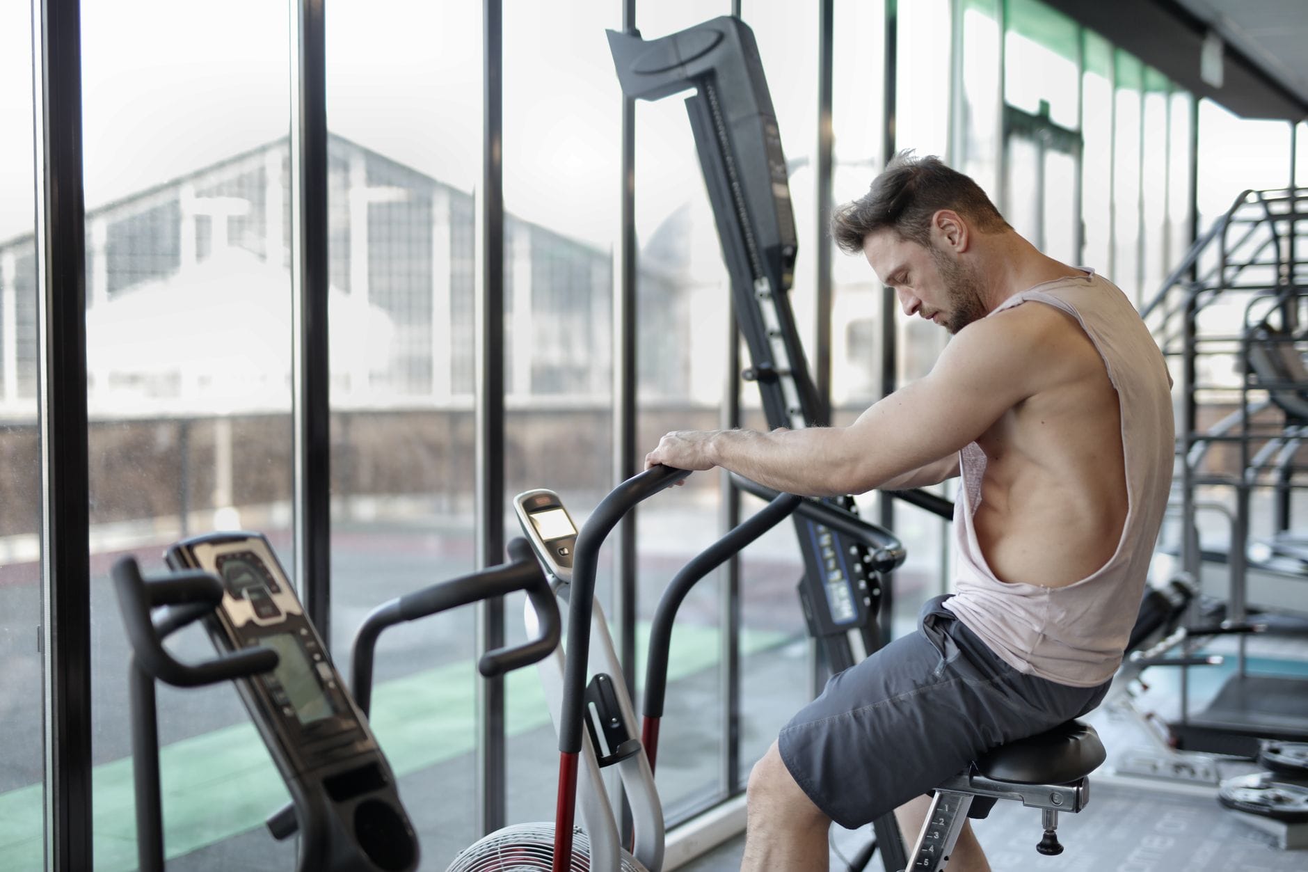 Umięśniony mężczyzna na rowerku stacjonarnym podczas treningu cardio
