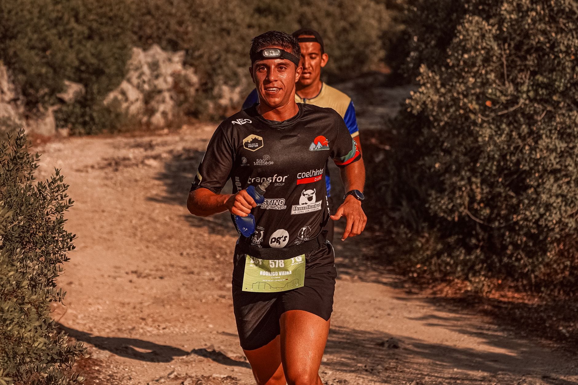 Biegacze na górskim maratonie z plecakami biegowymi