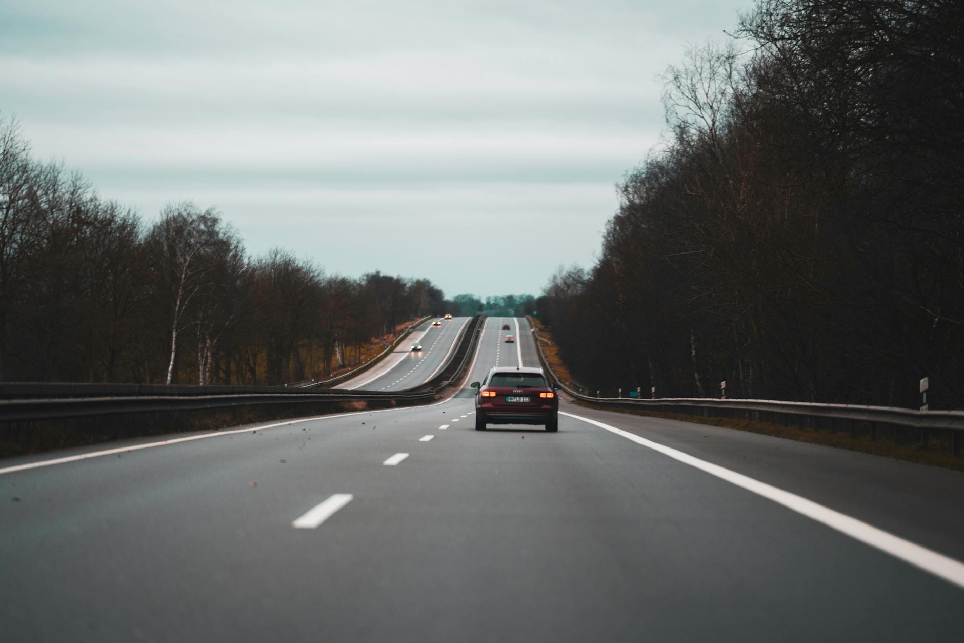 Samochody na jesiennej autostradzie między bezlistnymi drzewami