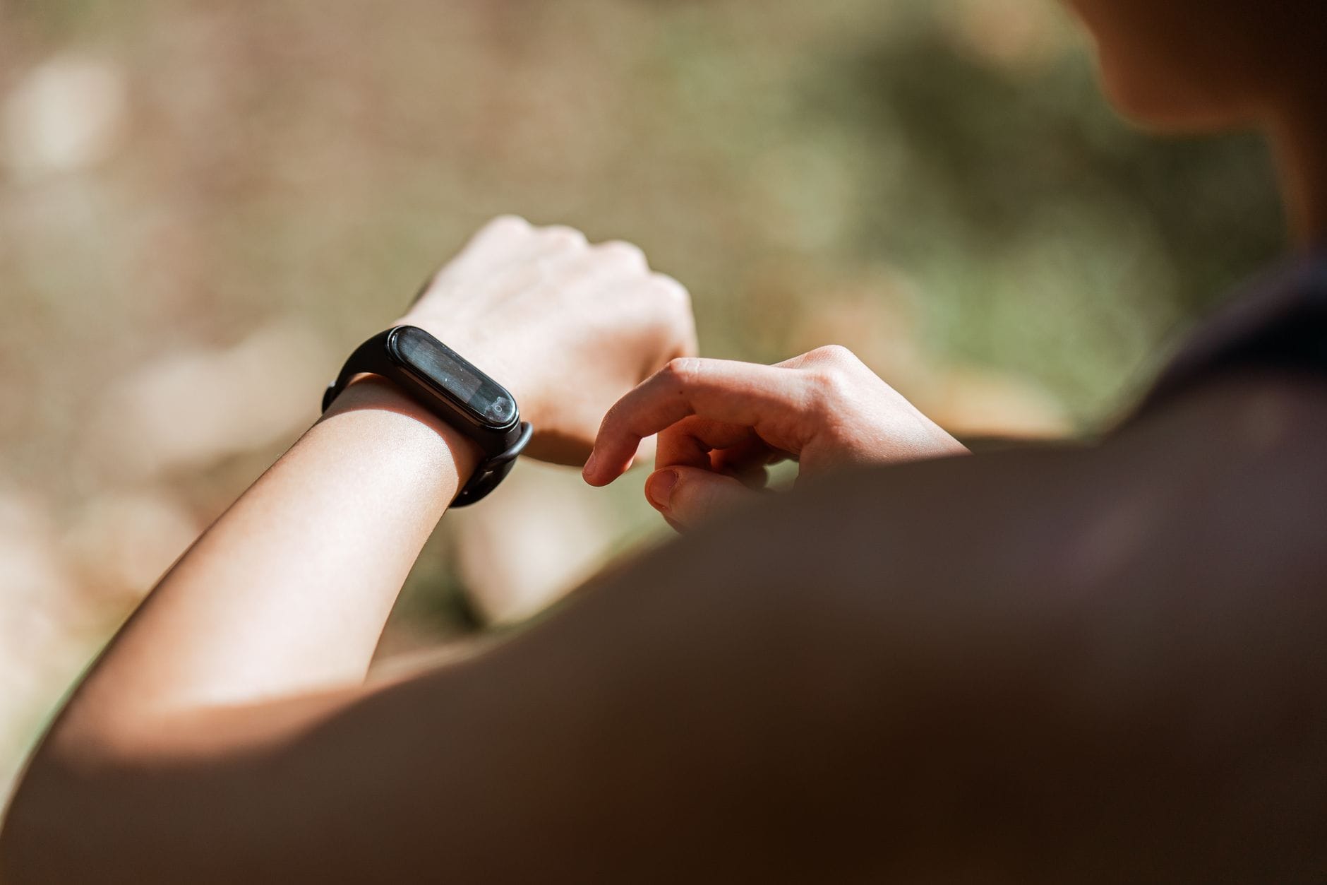 Biegaczka sprawdzająca powiadomienia na sportowym smartwatchu na zewnątrz Biegaczka sprawdzająca powiadomienia na sportowym smartwatchu na zewnątrz