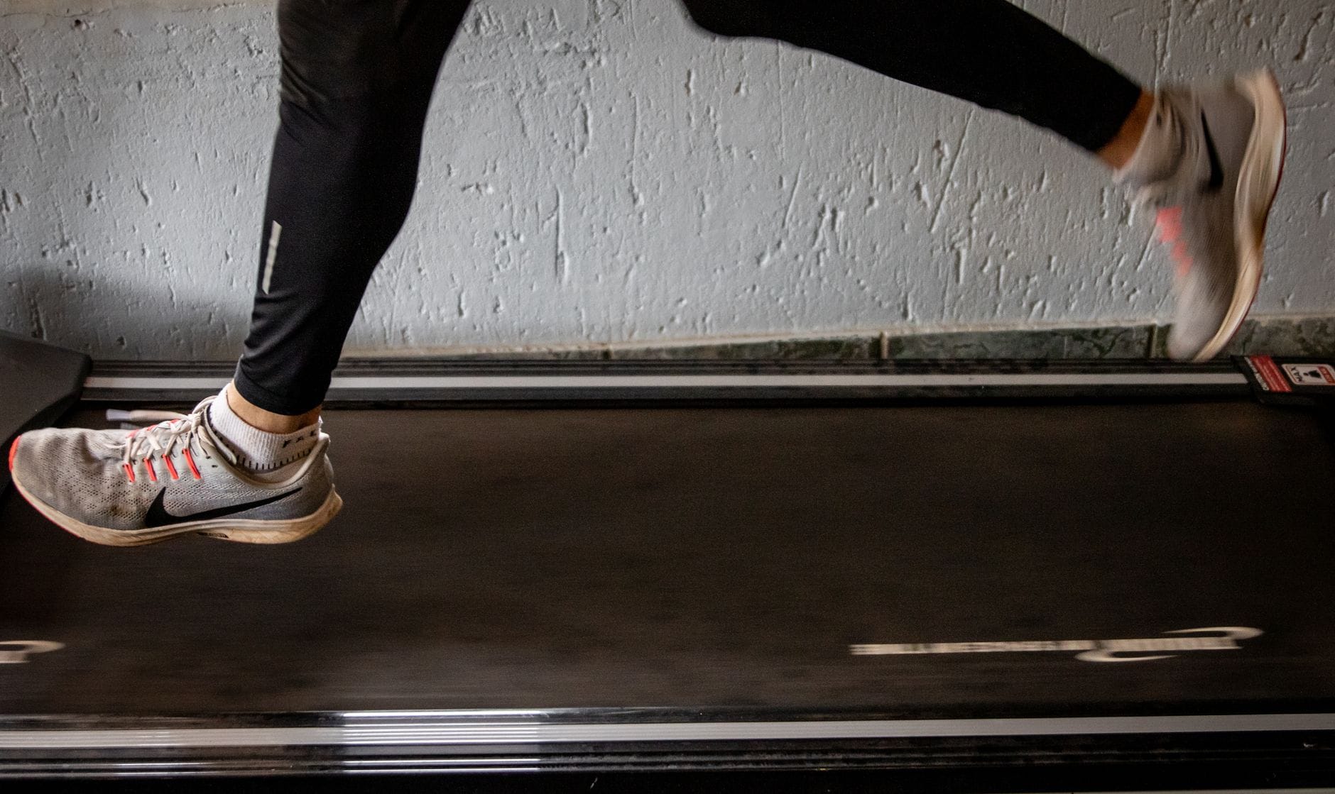 Trening na bieżni mechanicznej: jak ustawić nachylenie i tempo, żeby miało sens Kobieta biegnąca na bieżni mechanicznej w klubie fitness