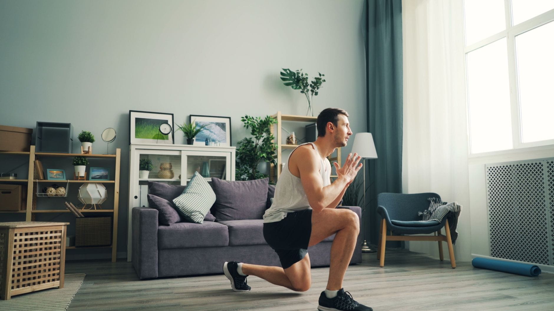 Mężczyzna wykonuje wykroki w pokoju hotelowym jako trening cardio