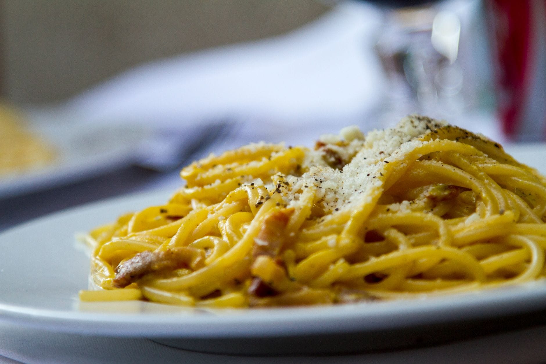 Zbliżenie na talerz spaghetti carbonara z tartym parmezanem Zbliżenie na talerz spaghetti carbonara z tartym parmezanem